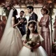 A dramatic and emotional scene at a wedding venue, where a family is in heated discussion. In the foreground, a young girl dressed in a flower girl ou