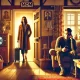 A dramatic and emotional illustration showing a young woman leaving a cozy living room, holding a suitcase and looking resolute, while a young man sit